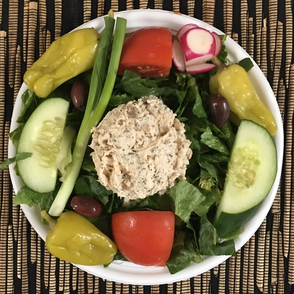 Woody's Famous Salads tuna salad with lettuce, cucumbers, tomatoes, radishes, olives, and peppers.